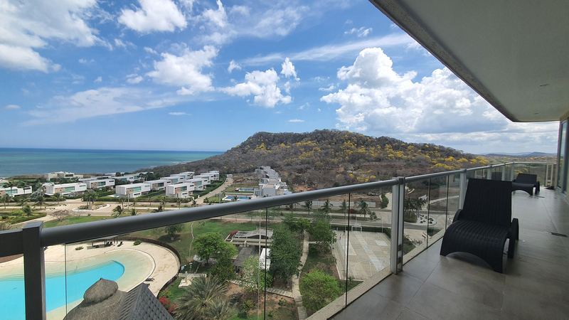 Agua Marina 803 — terraza con vista al mar y a las piscinas del condominio