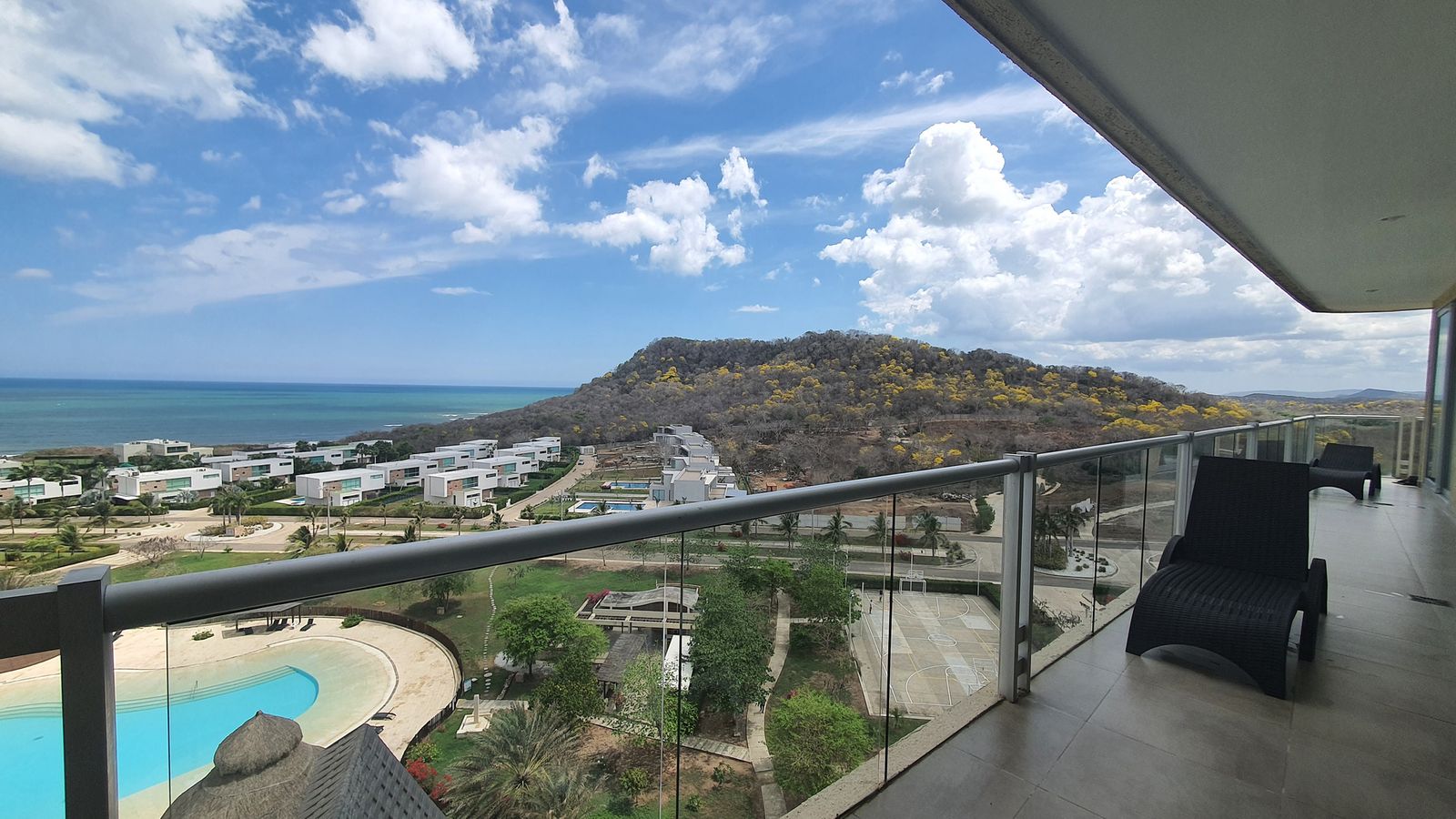Agua Marina 803 — terraza con vista al mar y a las piscinas del condominio